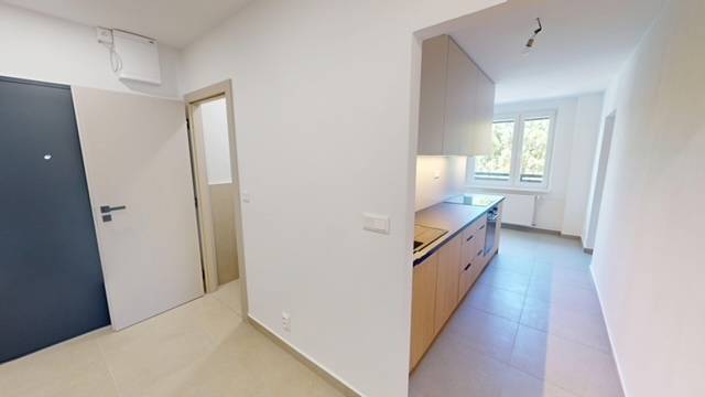 Hallway and kitchen in a 2-room apartment with a window, bright interior.