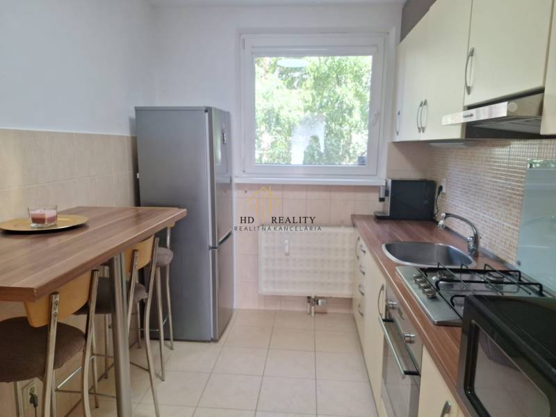 A kitchen in a 3-room apartment with a bar counter and appliances, bright atmosphere.