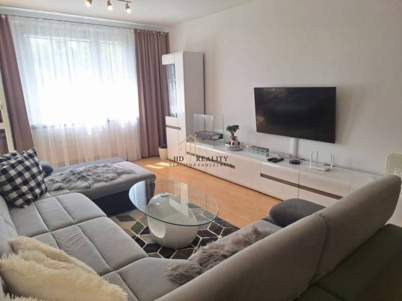 Living room in a 3-room apartment with a sofa, TV, and coffee table.