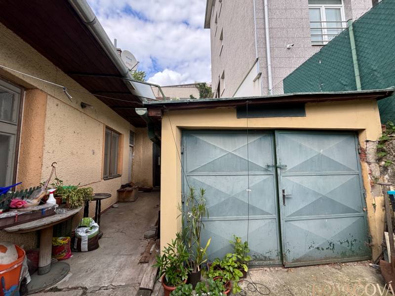 A yard in Ilava with a garage and outdoor seating at a family house.