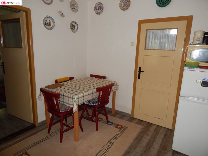 Dining room in a cottage with a wooden table and round decorations on the wall.