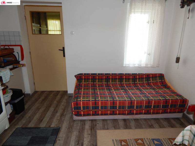 A cabin with a comfortable sofa, a carpet, and doors leading to another room.