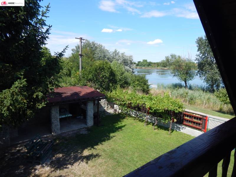A garden with a gazebo by the lake and greenery from the cottage in Klížska Nemá.