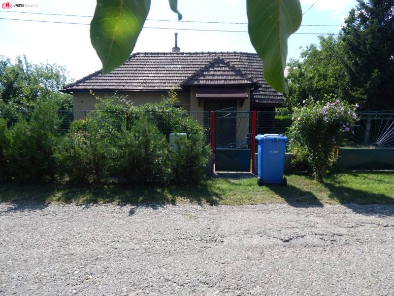 The exterior of the cottage in Klížska Nemá, surrounded by greenery and a gate.