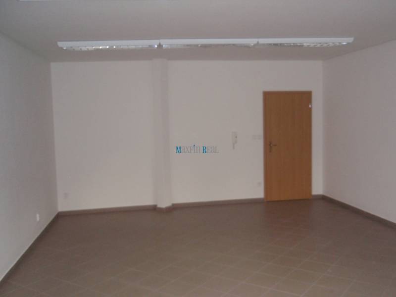 An empty office space with brown tiles and wooden doors.