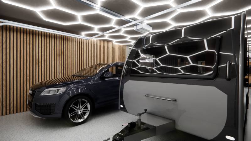 A car and a caravan inside commercial premises with lighting and wooden walls.