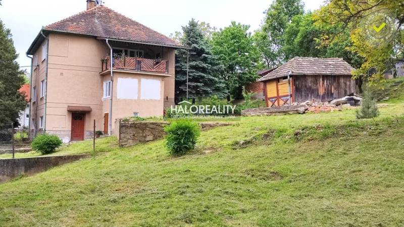 A family house in České Brezové with a landscaped garden and a wooden annex in the background.