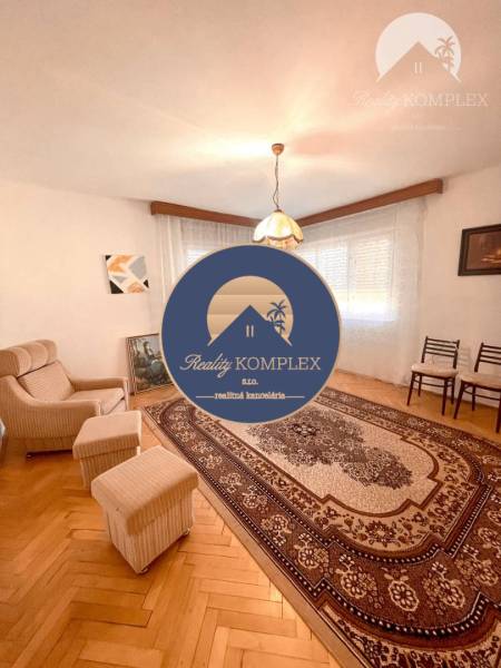 Living room in a family house, armchairs, carpet with ornaments, and pendant light.
