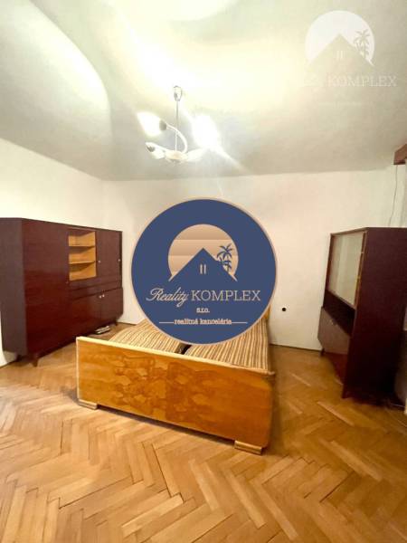 A bedroom in a family house with older furniture and a wooden floor.