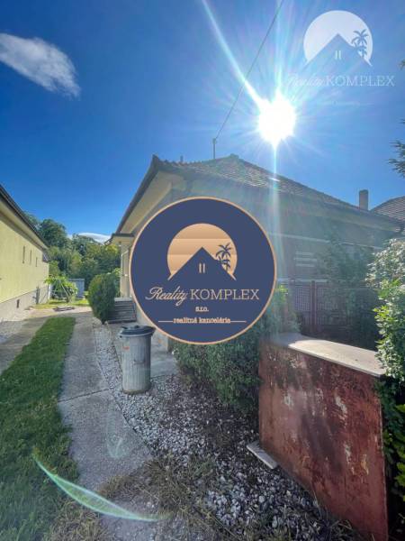 A family house in Veľké Blahovo with an access road and a garden under the clear sun.