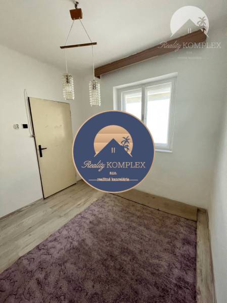 A room in a family house, bright interior, wooden beam, chandelier, purple carpet.