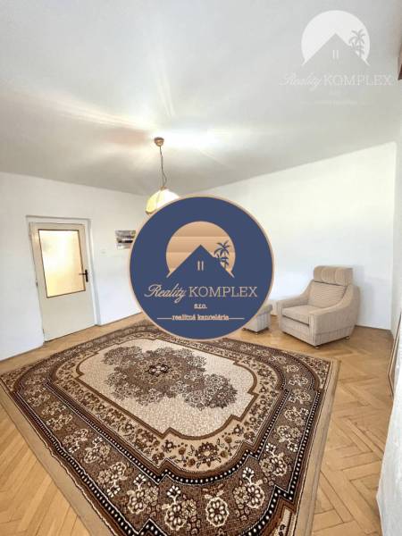 Living room in a family house with a carpet and an armchair.