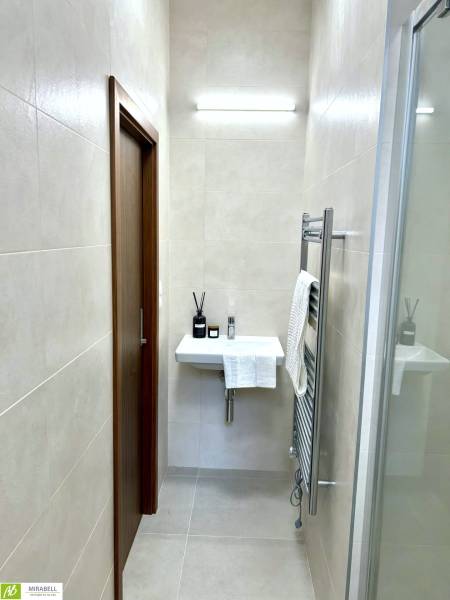 Bathroom with a sink and lighting in a 2-room apartment, with a minimalist design.