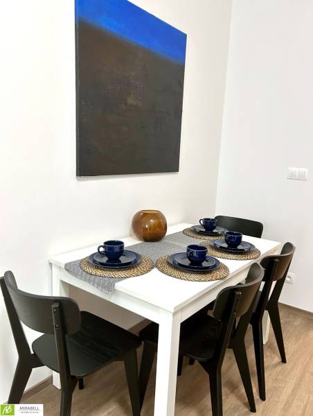 Dining table with four chairs, a painting on the wall in a 2-room apartment.