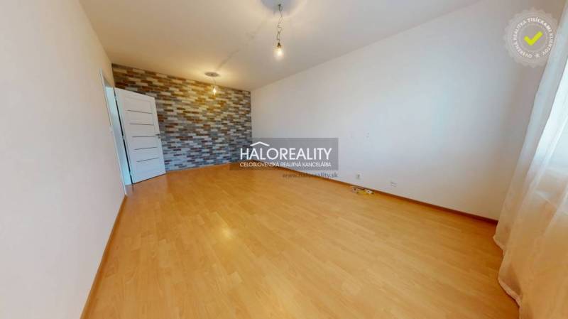 A room in a 4-room apartment with a parquet floor and a decorative brick wall.