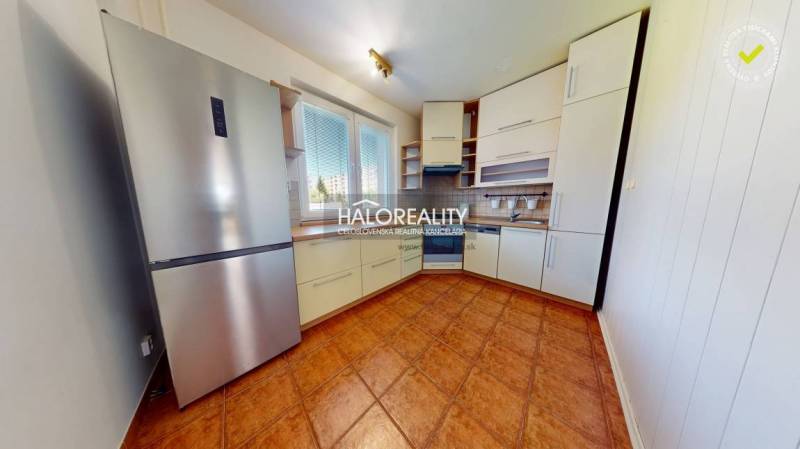 A kitchen in a 4-room apartment with a modern kitchen unit and a refrigerator.