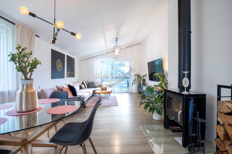 Living room of a family house with a fireplace, comfortable sofa, and glass table.
