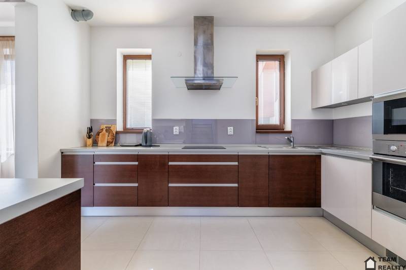 A kitchen in a family house with appliances and wooden cabinets.