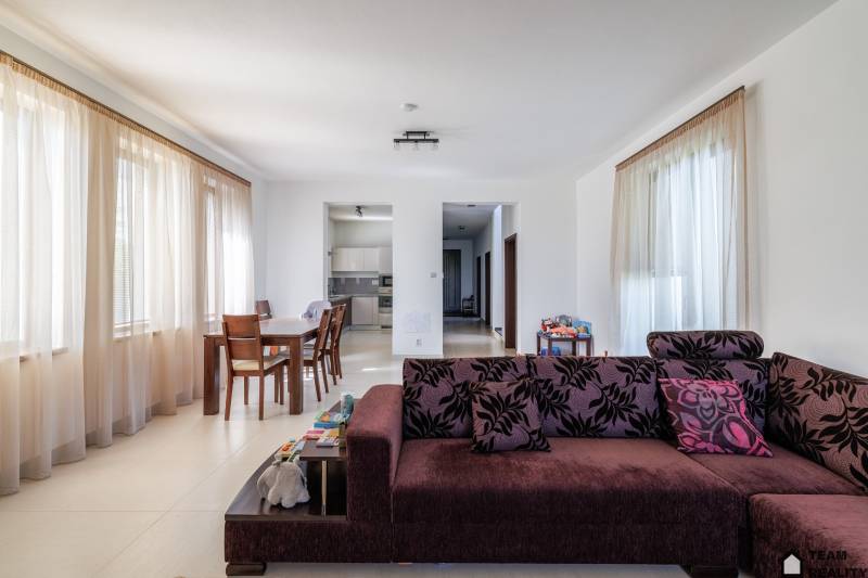 Living space with a dining table and sofa in a family house.