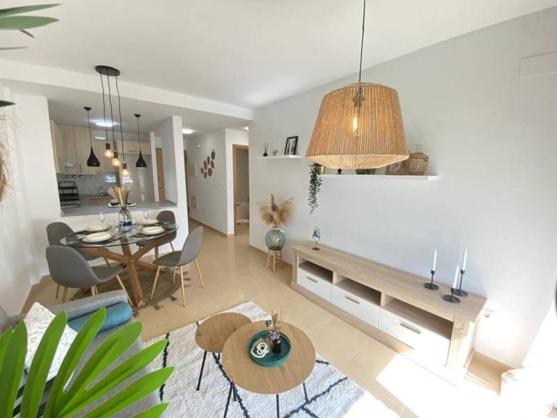 Interior of a 3-room apartment with a dining table, living room, and a vase on the floor.