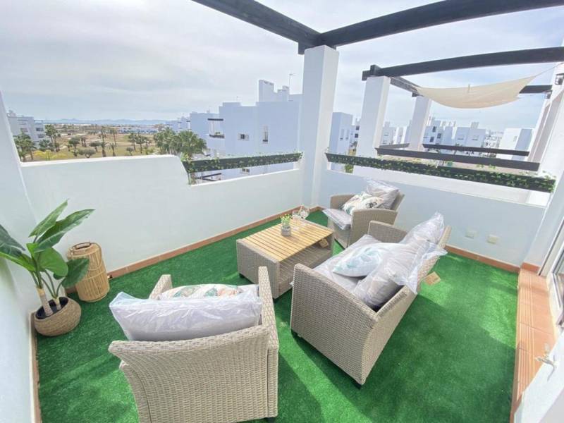 A terrace with a view in a 3-room apartment, with seating and artificial grass.