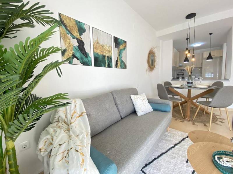 Living room with a sofa, decorations, and a dining area in a 3-room apartment.