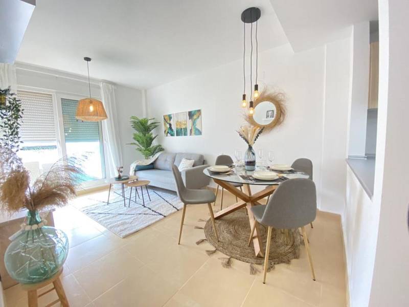 Bright living room of a three-room apartment with a dining area and a sofa.