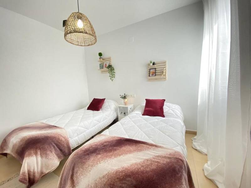 Two beds with bedspreads and decorative pillows in a 3-room apartment.