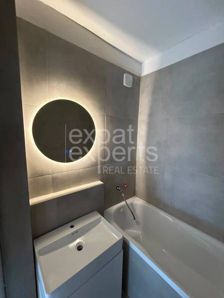 Bathroom with a bathtub and a sink in a 2-room apartment.