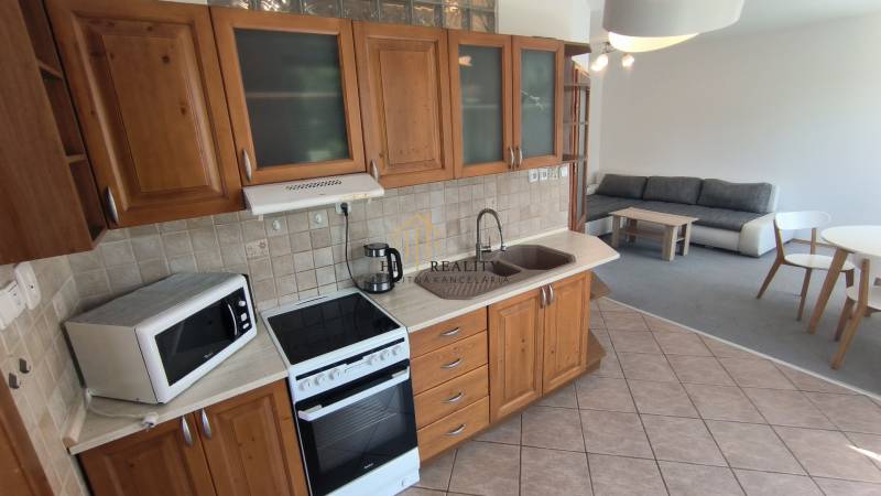 A kitchen unit with a dining table and a sofa in a 2-room apartment.