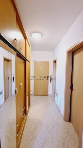 Hallway in a 3-room apartment with wooden built-in wardrobes and ceramic tiles.