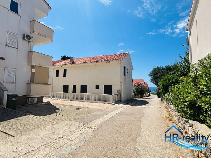 A view of the street with buildings in Novalja, near the sea, in front of a 2-room apartment.