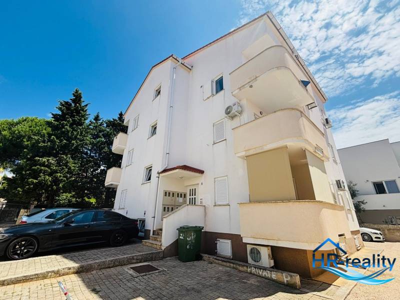 Exterior of the building with a parking lot and 2-bedroom apartments in Novalja.