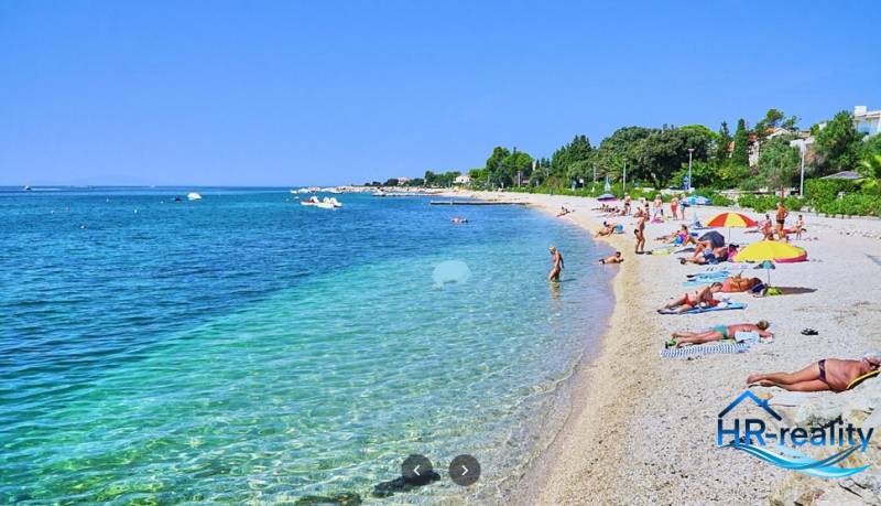 The beach in Novalja with tourists relaxing by the sea.