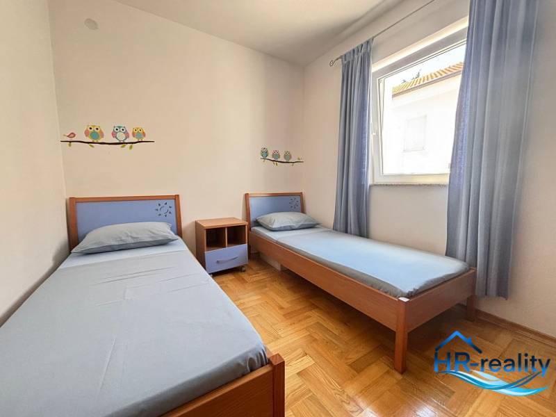 A children's room with two beds in a two-room apartment, decorated with owl stickers.