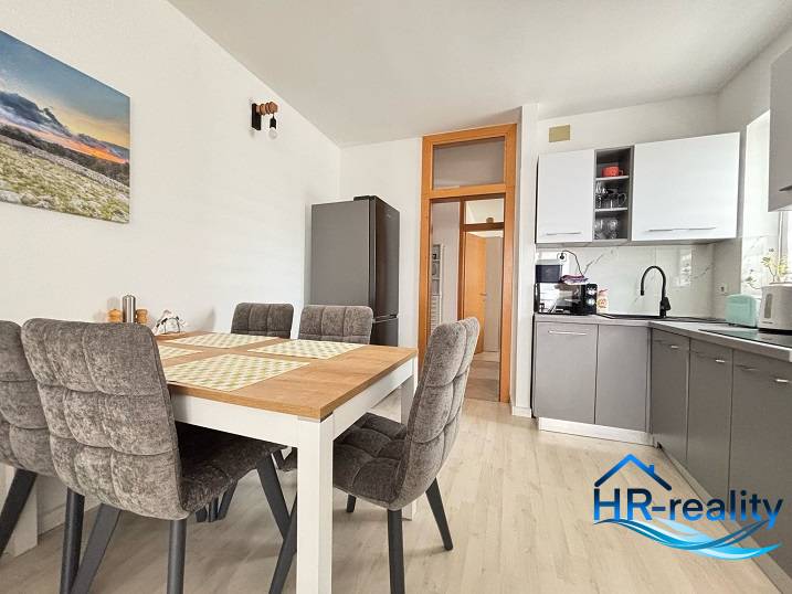 Dining area with kitchen in a 3-room apartment with a dining table.