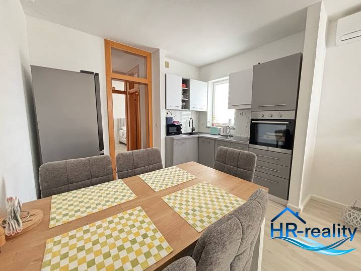 A kitchen in a 3-room apartment with a dining table and modern equipment.