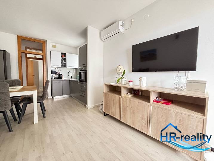 Living room in a 3-room apartment with a kitchen and dining table.
