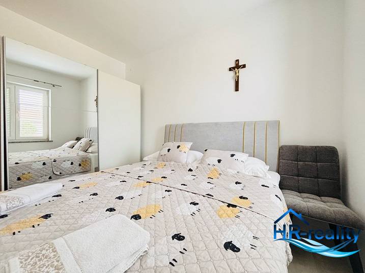 A bright bedroom with a mirrored wardrobe, a bed, and a chair in a 3-room apartment.