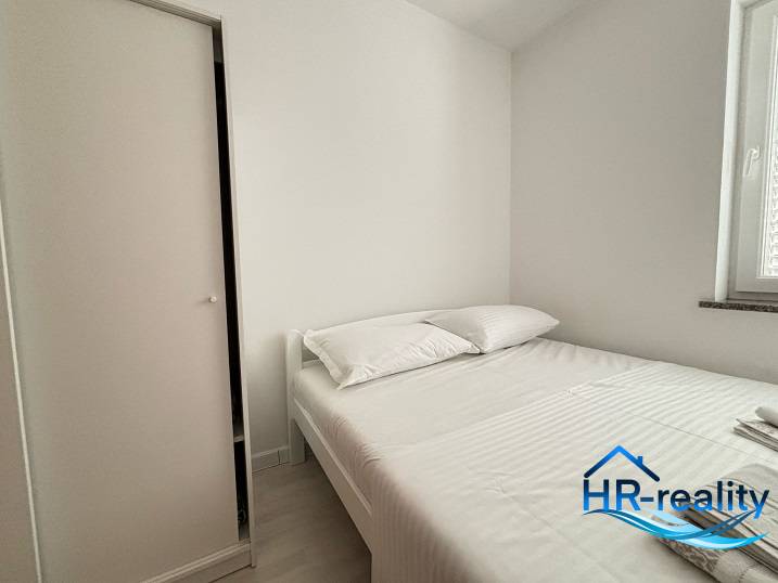 A bright bedroom with a comfortable bed and a white wardrobe in a 3-room apartment.