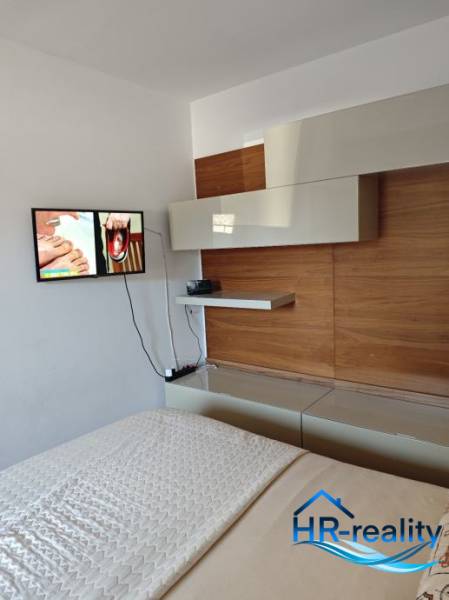 Interior of a 2-room apartment with a bedroom and TV, modern furniture on the wall.