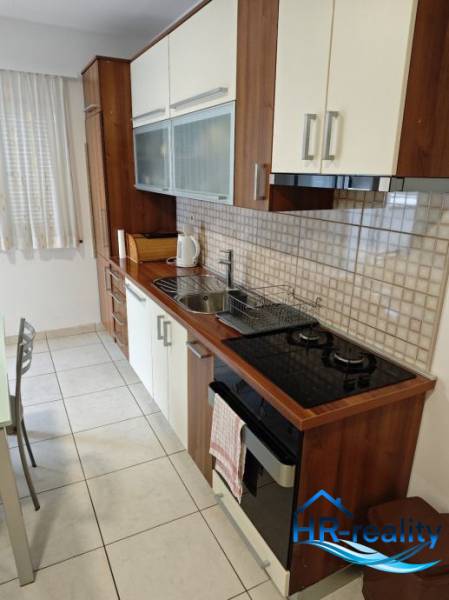 A kitchen in a 2-room apartment, equipped with appliances and storage spaces.