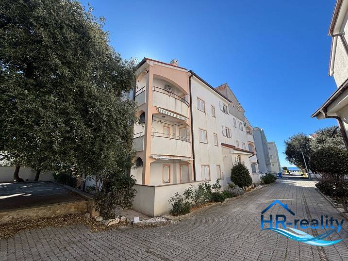 The exterior of an apartment building in the city of Novalja, for a 2-room apartment, with a paved road.