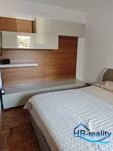 A bedroom in a 2-room apartment with wooden furniture and a comfortable bed.