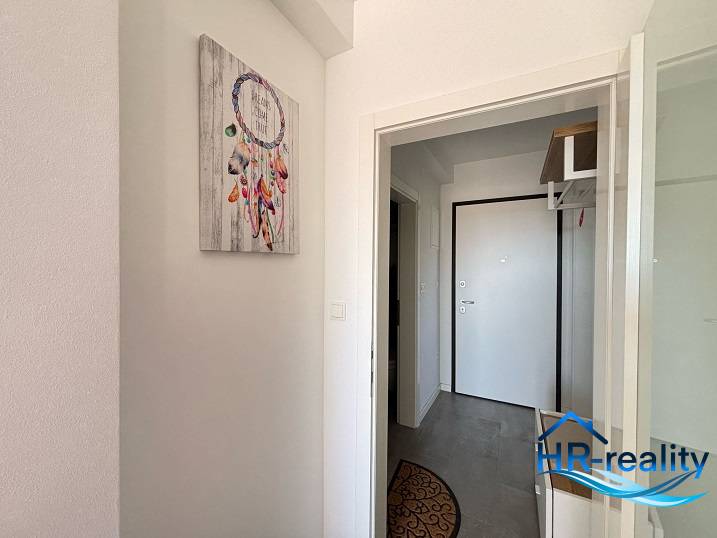 Entrance hallway in a 2-room apartment with a dreamcatcher picture on the wall.
