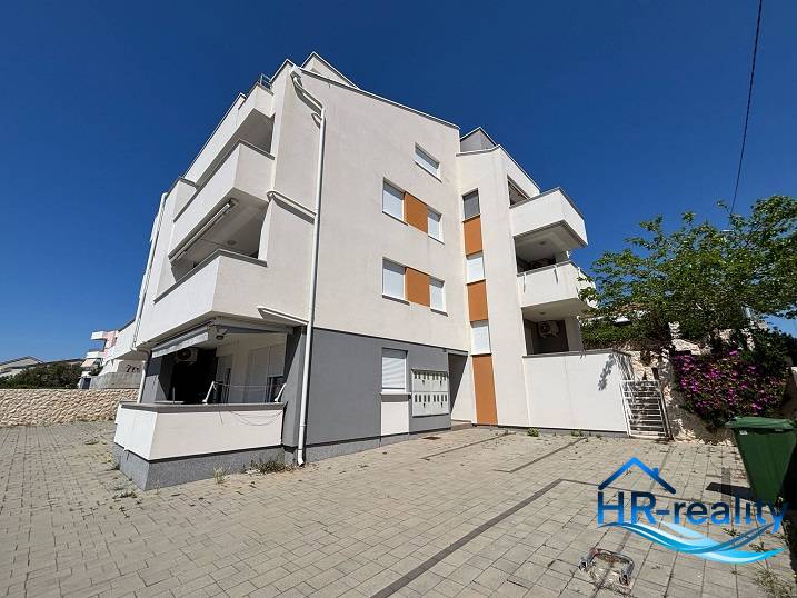 An apartment building with 2-bedroom apartments in the city of Novalja, with spacious parking.