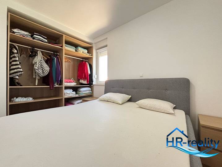 Bedroom with a double bed and a wardrobe in a 2-room apartment.