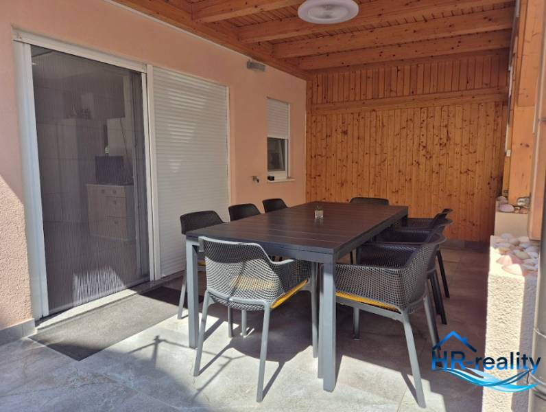 The 2-room apartment has a spacious terrace with a large dining table.