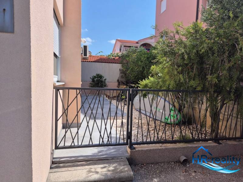 Enter through the gate with stones and a surfboard at the 2-bedroom apartment in Novalja.