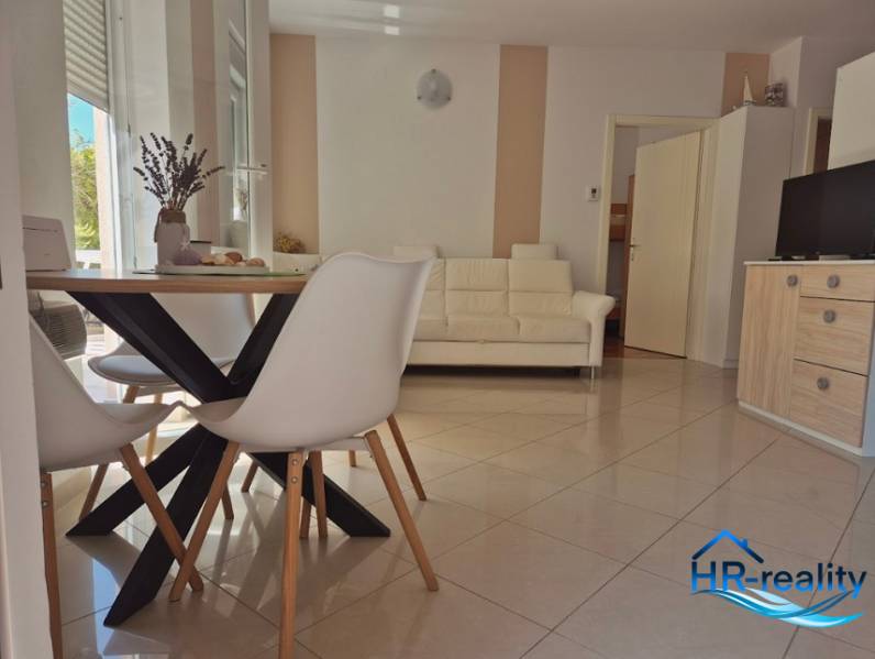Interior of a 2-room apartment with a bright living room, dining table, and sofa.